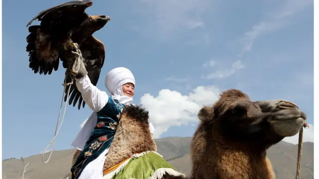 Участница соревнований по соколиной охоте верхом на верблюде