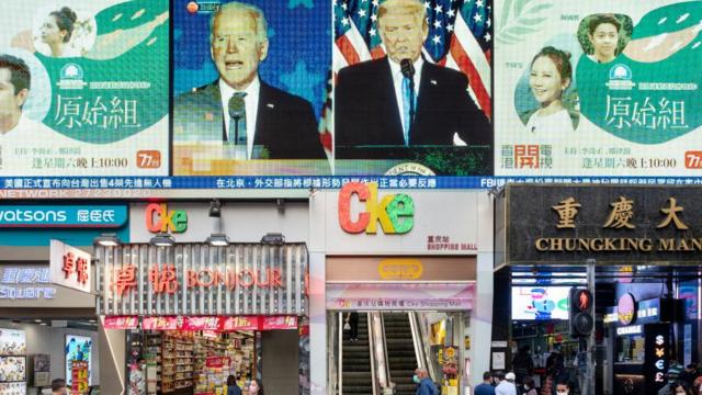 Calle en Pekín con imágenes de Trump y Biden.