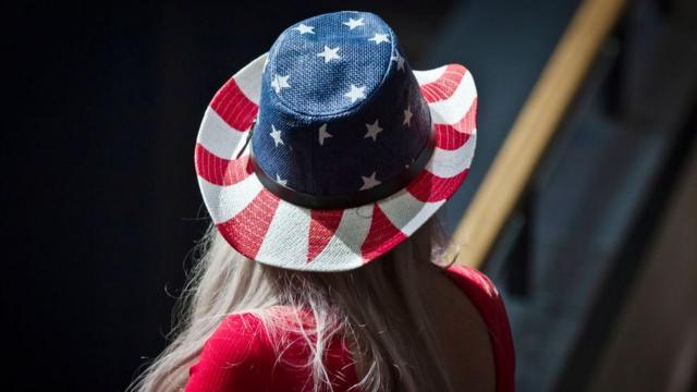 Mujer de espaldas con un sombrero con los colores de la bandera de Estados Unidos.