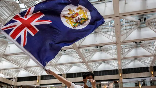 香港中環某購物商場內一名「反送中」示威者揮舞港英年代旗幟（1/6/2020）