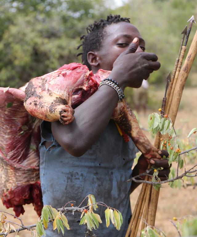 Homem hadza com arco, flecha e um pedaçoapostas online gratiscarne