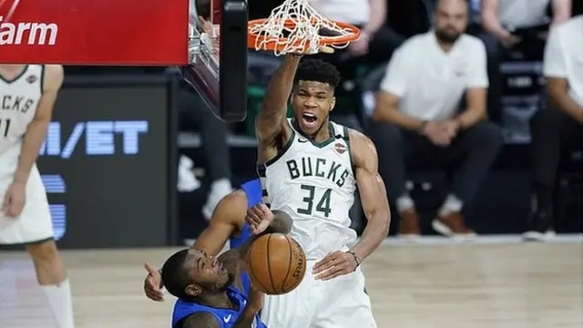 Milwaukee Bucks star Giannis Antetokounmpo dunks over Gary Clark of the Orlando Magic