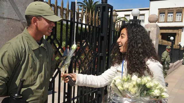 ২০১১ সালে মরক্কোর রাবাতে একজন আন্দোলনকারী ফুল দিচ্ছেন নিরাপত্তারক্ষীকে