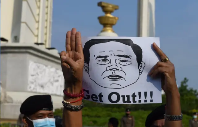 มือชูสามนิ้วข้างรูปวาดหน้าประยุทธ์