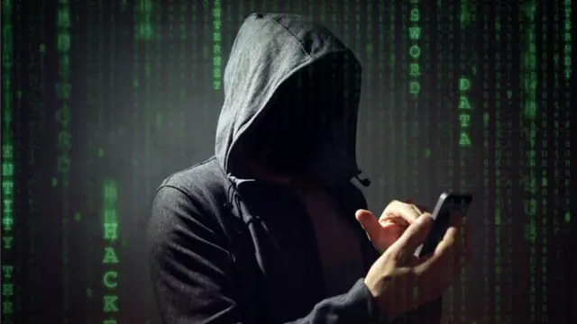 Hombre encapuchado con un teléfono.