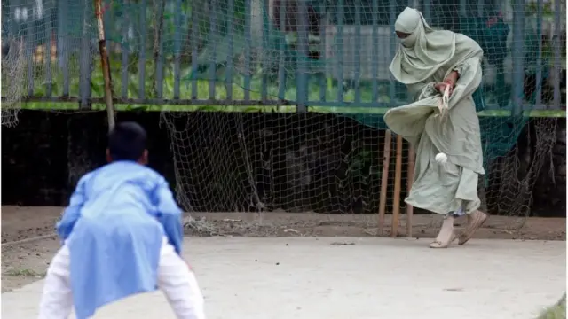 ছেলের বলে ব্যাট করছেন মা।