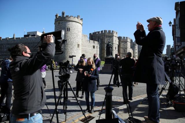 Members of the media gather outside Windsor Castle on the day of the funeral of Britain's Prince Philip, husband of Queen Elizabeth, who died at the age of 99, in Windsor, near London, April 17, 2021.
