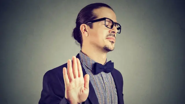 Hombre de traje con actitud arrogante.