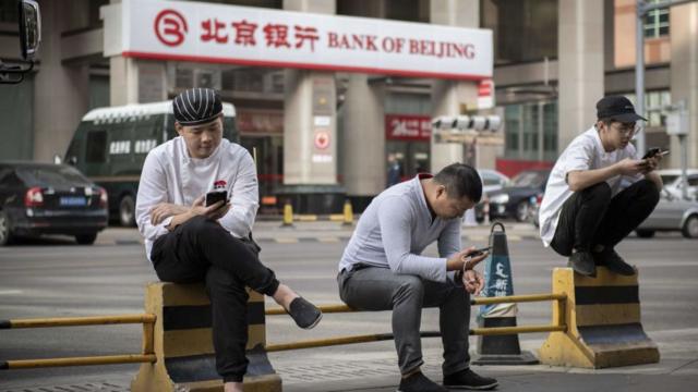 Ciudadanos mirando el teléfono móvil en China.