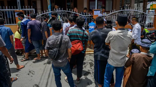Muslims lining up to wash their hands before entering the mosque to perform Friday prayers at the An-Nur Palupi Mosque, Palu, Central Sulawesi, Indonesia on March 27, 2020. Although the Indonesian Ulema Council (MUI) has issued a fatwa about not having to carry out Friday prayers in congregation at mosque to avoid exposure to the corona virus, but a number of mosques still carry it out with strict regulations for worshipers.