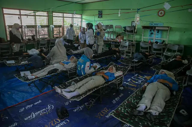 Para siswa beristirahat di tempat tidur portabel sambil menerima perawatan akibat keracunan makanan setelah mengonsumsi makanan sekolah gratis bersubsidi pemerintah di SMPN 1 Cisarua, Kabupaten Bandung Barat, Jawa Barat.