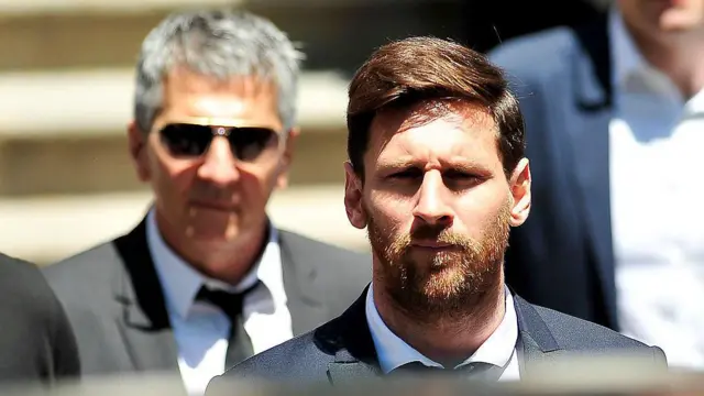 Jorge Messi de corbata y traje negro junto a su hijo Lionel Messi que lleva un traje similar.