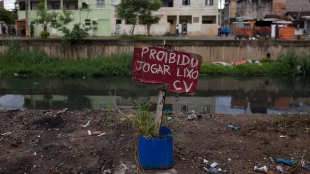 Um cartaz de "Proibido jogar lixo" assinado pelo Comando Vermelho, facção criminosa que controla a Cidade de Deus, favela onde a foto foi tirada em 2018