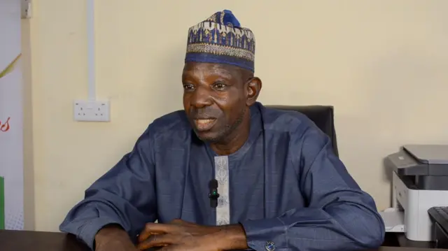 Agbẹnusọ fun gomina ipinlẹ Kwara, Rafiu Ajakaye nigba to n ba BBC sọrọ, o wọ asọ alawọ omi aro, o si de fila si pẹlu. O ka ọwọ sori tabili ninu ọọfisi rẹ, awọn ẹrọ ti wọn fi n se ẹda iwe wa lẹgbẹ alaafia rẹ.