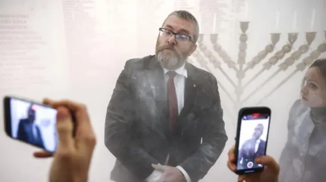 Grzegorz Braun, członek skrajnie prawicowej partii Konfederacja, został sfotografowany po użyciu gaśnicy do zgaszenia świec na menorze zapalonej podczas obchodów Chanuki w budynku parlamentu w Warszawie.
