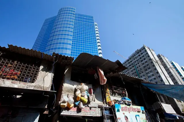 Un bidonville de Mumbai avec un immeuble de luxe à l'arrière