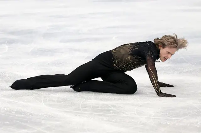 El estadounidense Ilia Malinin con las piernas y las manos sobre la pista de hielo en una prueba de Milán-Cortina 2026