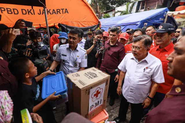 Ketua Umum Palang Merah Indonesia (PMI) Jusuf Kalla (kedua kanan) menyerahkan bantuan kepada perwakilan korban kebakaran saat meninjau posko pengungsian di SDN Kebon Kosong 09, Kemayoran, Jakarta, Rabu (11/12/2024). Dalam kunjungannya Jusuf Kalla memastikan kebutuhan pengungsi terpenuhi dan meninjau langsung lokasi kebakaran yang melanda 197 rumah di Kebon Kosong.
