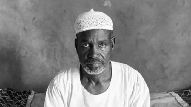 Mohammed Abbaker Adam, barbu, portant une casquette blanche et un thobe