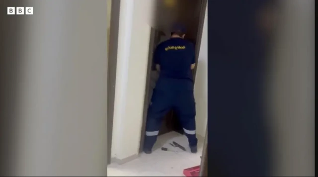 Sawir ay BBC-du ka heshay dadkii la hadlay ayaa muujinaya askari ka tirsan ciidamada difaaca madaniga ah oo ay la socdaan booliis oo si xoog ah albaabka uga furaya 