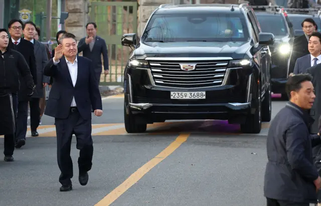 윤석열 대통령이 8일 서울구치소에서 걸어나오며 지지자들에게 인사를 하고 있다