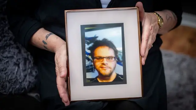 ኤንጅላ የልጇ ብሬትን ፎቶ ይዛ