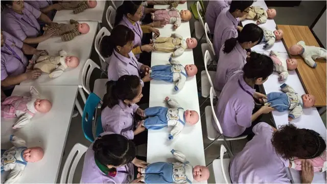 Image of women looking at baby dolls
