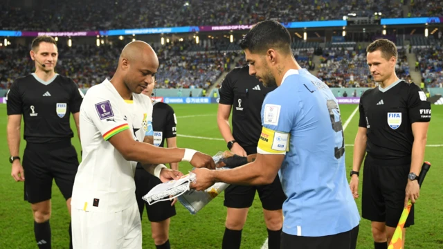 Photo of Andre and Luis Suarez exchanging penants