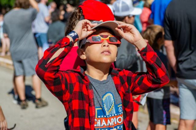 un niño ve un eclipse solar con gafas especiales