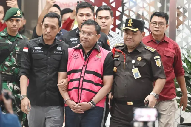 Mantan Wakil Kepala Badan Gizi Nasional, Sony Sonjaya (tengah), berjalan memasuki mobil tahanan di Kejaksaan Agung, Jakarta, Rabu (03/06).