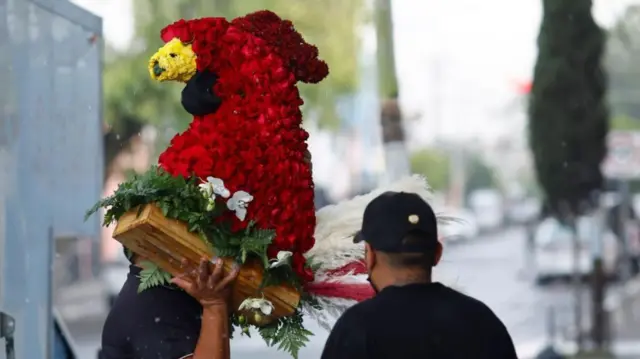 Un homenaje en forma de gallo estaba entre los arreglos florales, muchos de los cuales supuestamente fueron recibidos de remitentes sin nombre