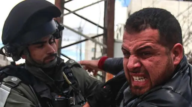 အနောက်ဘက်ကမ်းမှာ အခြေအတင်ဖြစ်နေတဲ့ အစ္စရေးစစ်သားနဲ့ ပါလက်စတိုင်း ဆန္ဒပြသူတစ်ဦး