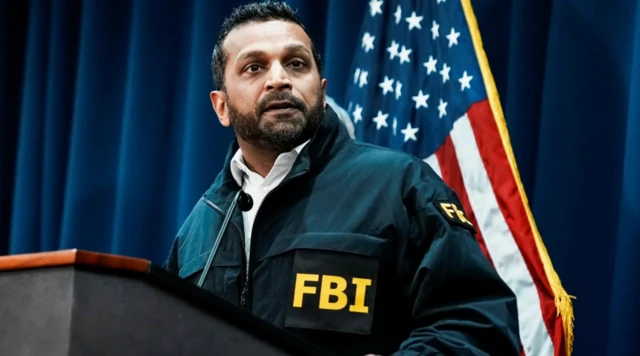 FBI yazılı mont giyen yönetici basın toplantısında konuşuyor