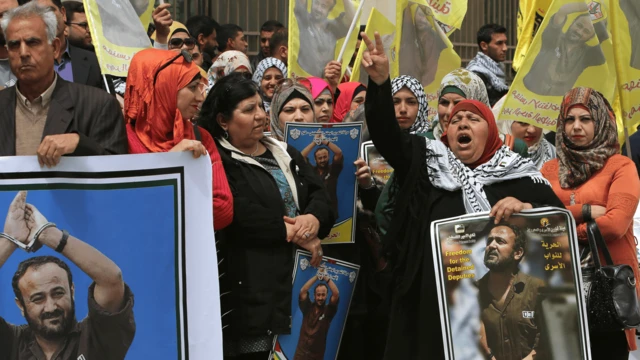 मरवान बरग़ूती की तस्वीर लिए फ़लस्तीनी प्रदर्शनकारी