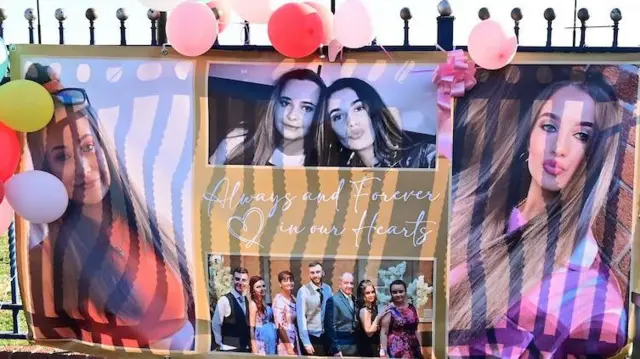 Un collage de fotos colgado en una valla metálica negra. Hay cuatro imágenes de Chloe: dos de ella sola y las otras dos con sus amigas. Alrededor de las imágenes hay globos multicolores.