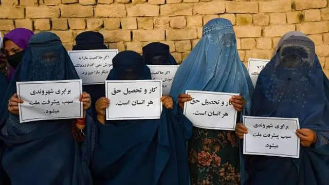 زنان برقعپوش افغان در ۱۲ آگوست-اوت ۲۰۲۳ در مزار شریف، پلاکاردهایی را در دست دارند و برای حق تحصیل خود اعتراض میکنند