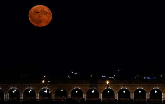 Засняли самолет, летевший над Buck Moon в небе над Парижем