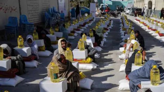 تصویری شماری از بازگشت کنندگان که از پاکستان آمده و کندهار از سوی صلیب سرخ کمک غذایی دریافت کرده اند. 