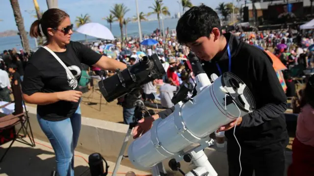 Jovens brancos seguram telescópiosfoguetinho da betanofrente a multidãofoguetinho da betanopraia no méxico 