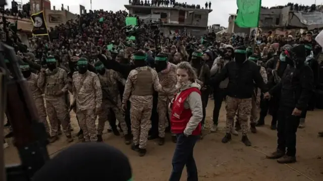 Wakiliyar ƙungiyar agaji ta Red Cross tsaye kusa da mayaƙan Hamas a lokacin da suke miƙa gawarwakin Isra'ilawa hudu a kudancin Zirin Gaza a watan Fabrairu