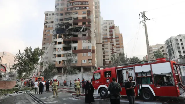 Bomberos trabajan en el lugar de un edificio dañado