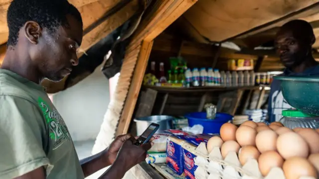 በሞባይሉ ከሱቅ ለገዛቸው እቃዎች ክፍያ የሚፈጽም ግለሰብ