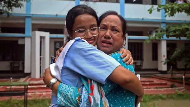 একজন নারী শিক্ষার্থী তার মাকে জড়িয়ে আনন্দে কাঁদছেন