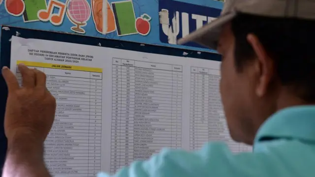 Orangtua murid mengecek nama siswa yang dinyatakan lulus pada Penerimaan Peserta Didik Baru (PPDB) di Sekolah Dasar Negeri 34 di Pontianak, Kalimantan Barat