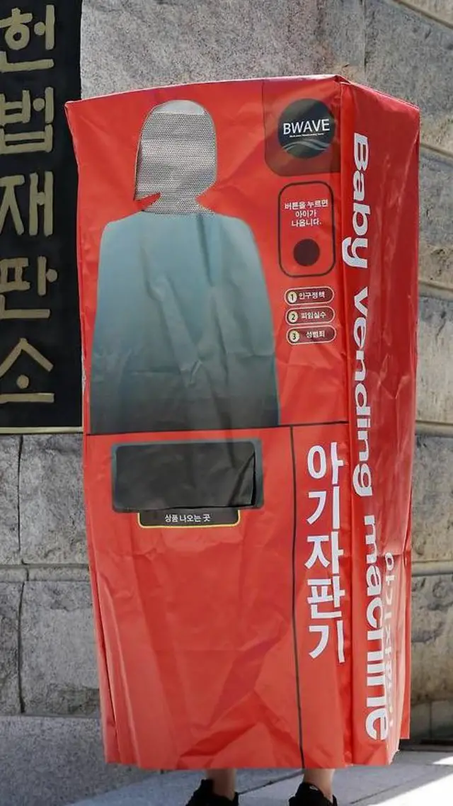 Feminist in S Korea wears a 'baby vending machine' costume for protest