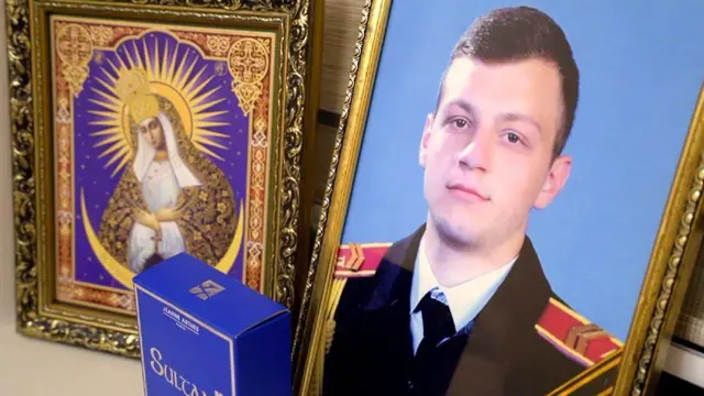  Picha ya Maksym akiwa katika sare zake za jeshi na biblia