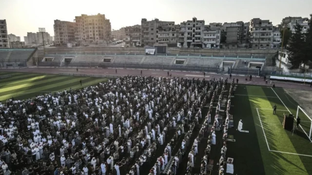 نازحون يعيشون في خيام بسبب الحرب الأهلية السورية يؤدون الصلاة في ملعب في إدلب 