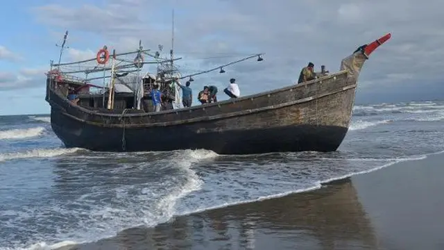 Warga memeriksa kapal pengangkut imigran etnis Rohingya yang mendarat di desa Kulee, kecamatan Batee, Kabupaten Pidie, Aceh, Minggu (19/11/2023).