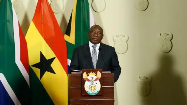 Ramaphosa looking at di camera wit Ghana and South Africa flag for di back