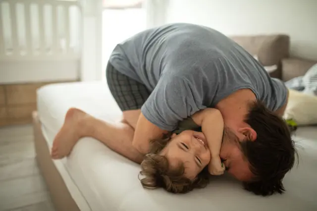 Father hugs his daughter tightly while playing together